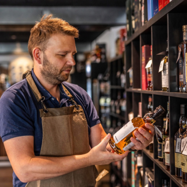 Theis in whisky shop looking at balvenie